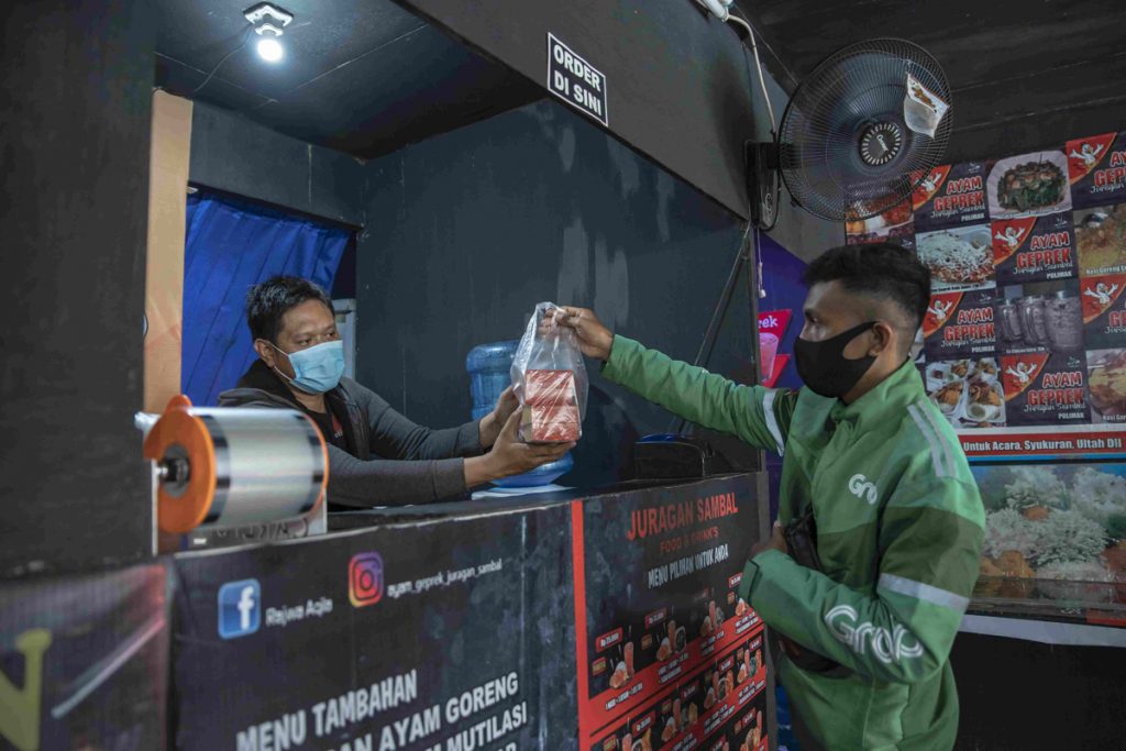 Satrio Supriono Pemilik Ayam Geprek Juragan Sambal di Jayapura menyerahkan pesanan ke Mitra GrabFood 1024x683
