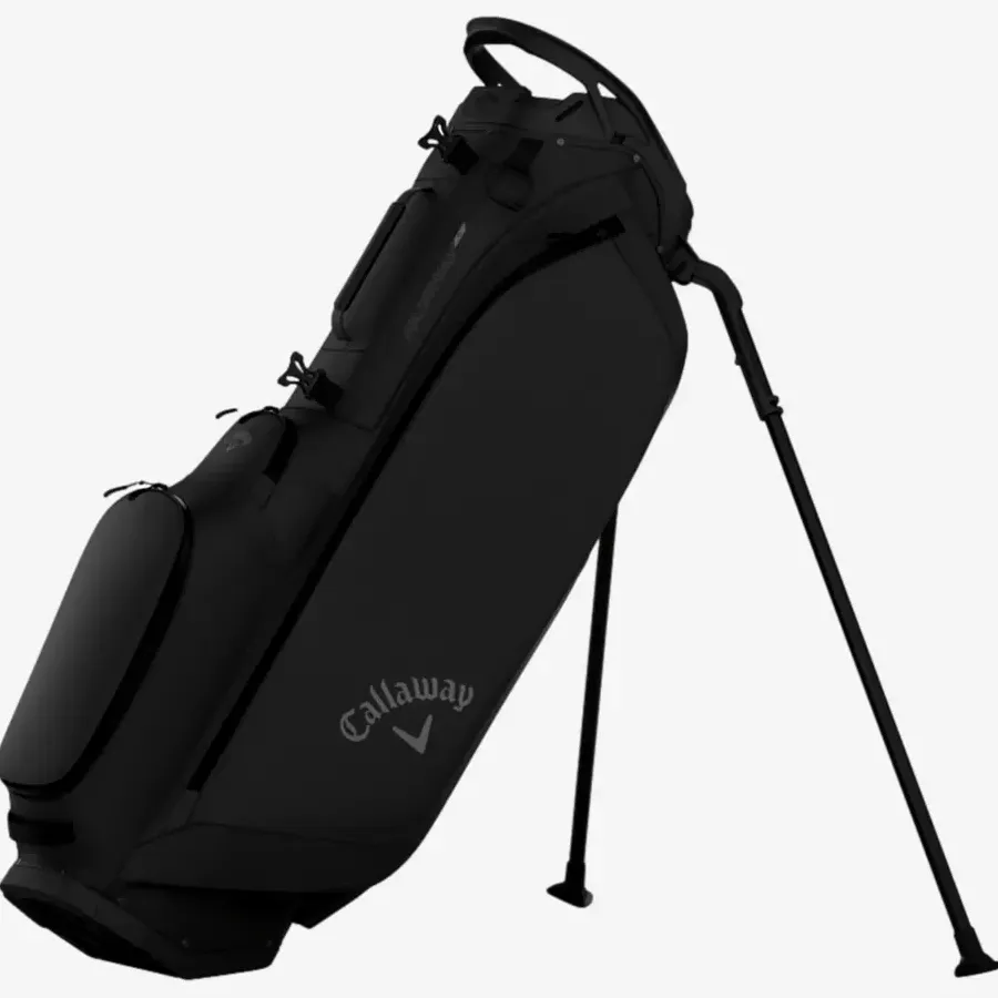 A black Callaway golf bag with stand legs extended, featuring multiple zippered compartments and a carrying handle on top, ranks among the best golf bags 2026, set against a plain white background.