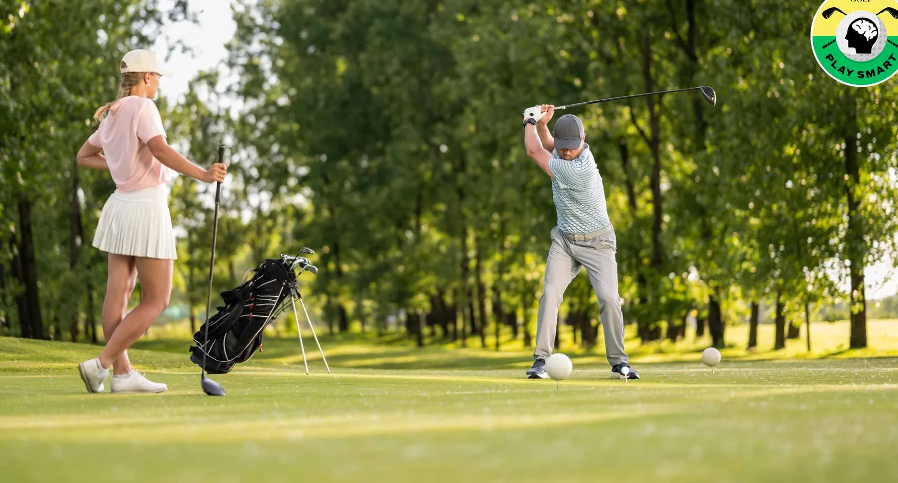 golfer swings while another golfer looks on
