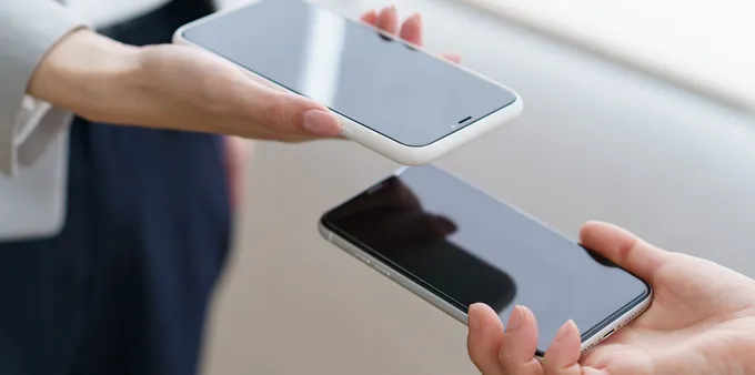 Two people holding their phones near each other to transfer files