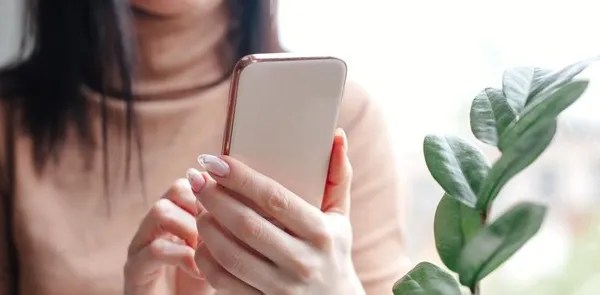 Close up young woman looking at smartphone for video online chat with friends or surf the internet or playing mobile application in relax time