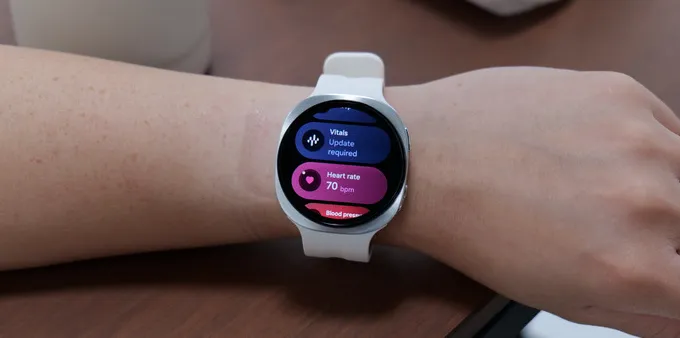 A smartwatch with heart rate and vitals features displayed.