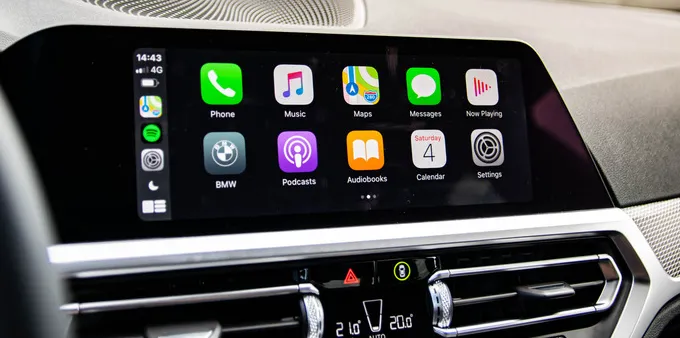 Apple CarPlay interface displayed on a BMW infotainment screen with apps for Phone, Music, Maps, Messages, Podcasts and Settings.